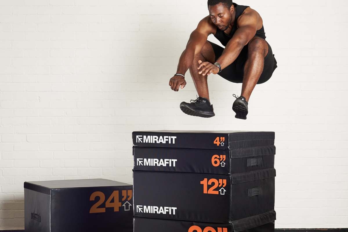 young healthy man jumping onto a stack of plyo boxes whilst doing a calorie burning exercise